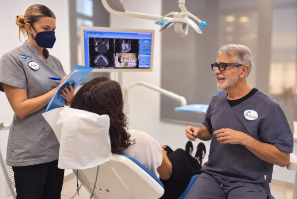 El Prof. Dr. Pedro Buitrago y la higienista Alba Escudero atienden a una paciente mientras revisan sus pruebas radiológicas durante una segunda opinión dental en Valencia