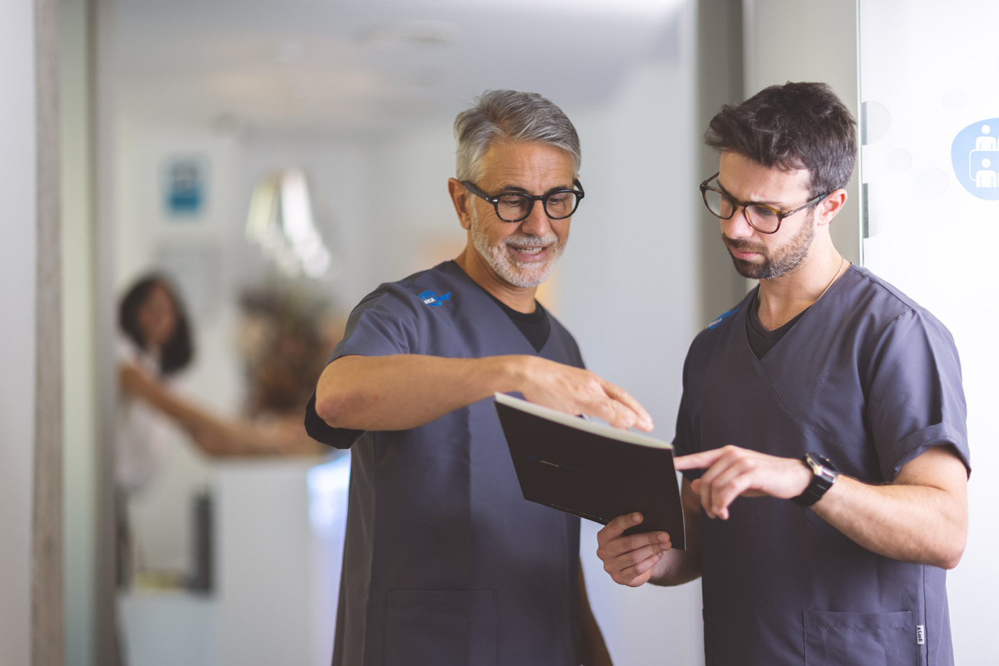El Prof. Dr. Pedro Buitrago revisa documentación clínica con el Dr. José Luis Navarro, responsable de Prótesis y Odontología Estética y Restauradora de Clínica Buitrago